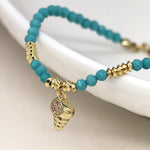 Golden shell charm and turquoise bead bracelet