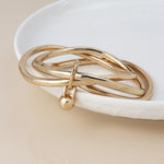 Golden bangle stack with ball charm